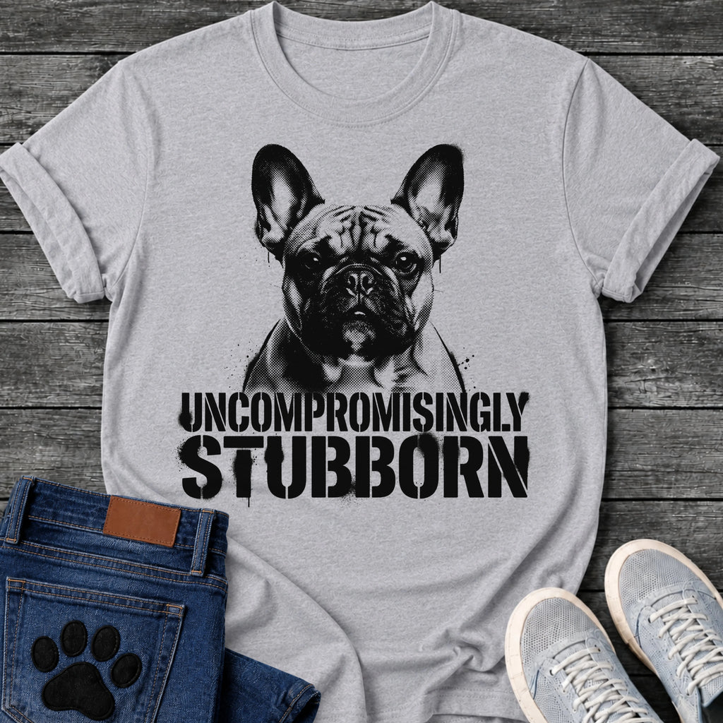 French Bulldog t-shirt with high contrast halftone Frenchie portrait facing forward with ink splatter drip details, bold oversized stencil text below reading Uncompromisingly Stubborn, single black ink graphic with serious streetwear energy
