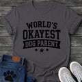 Varsity style graphic tee design reading "World's Okayest Dog Parent," with a banner ribbon and three stars underneath.