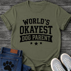 Varsity style graphic tee design reading "World's Okayest Dog Parent," with a banner ribbon and three stars underneath.